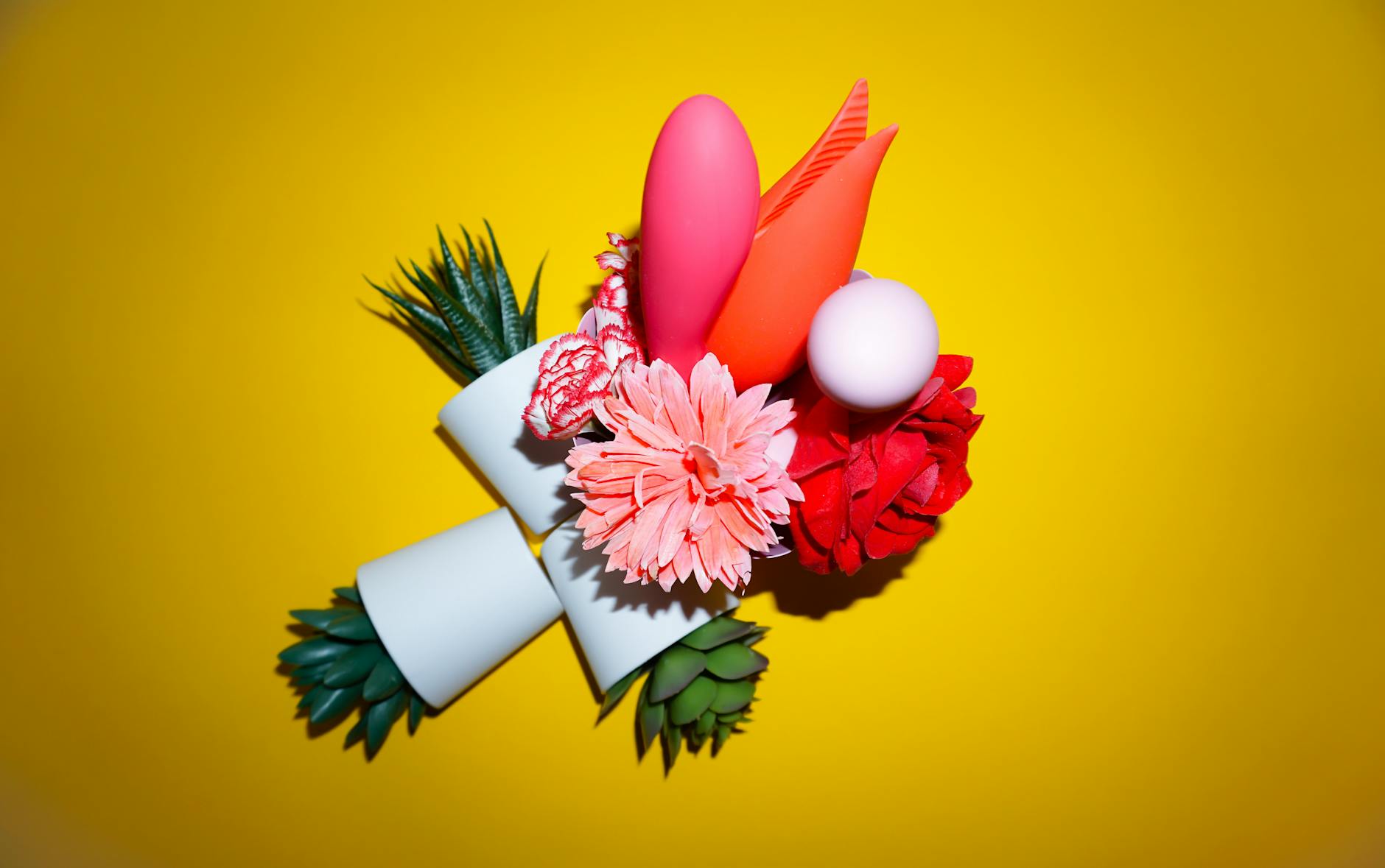 Vibrant collection of clitoral vibrators and adult toys arranged on a bright yellow surface